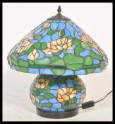A large Tiffany style table tamp having a large leaded stained glass bulbous body and matching