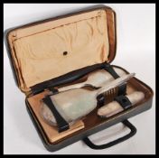 An early 20th Century hallmarked silver three piece travelling vanity set consisting of brushes