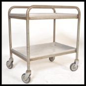 A vintage 20th century retro industrial medical dentist trolley of tubular form raised on large