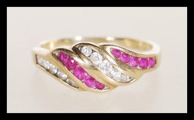A hallmarked 9ct gold red and white stone set ring having bands of flush set red and white stones.