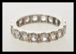 A stamped 9ct white gold eternity ring set with white stones. Tests as 9ct. Weight 3.5g. Size M.