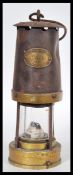 A vintage early 20th Century miner's safety lamp, applied plaque reading Paterson Lamps Ltd of