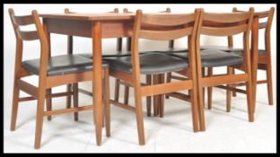 A vintage retro 20th Century teak Danish influence dining table suite with a set of six vintage teak