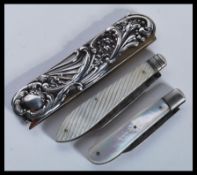 Two silver hallmarked folding mother of pearl fruit knives / pen knives. Both with Sheffield assay