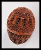 A 19th Century treen carved coquilla nut, the nut carved for use as a nutmeg grinder holder, the