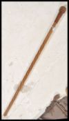 An early 20th Century carved walking stick cane having a twist design to the staff with large