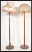 Two 20th Century Art Deco oak standard lamps with shades, both with turned uprights supported by a