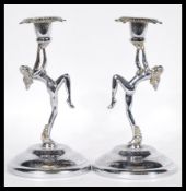 A pair of 20th Century Art Deco style chrome candlesticks having figural maidens or spirit of