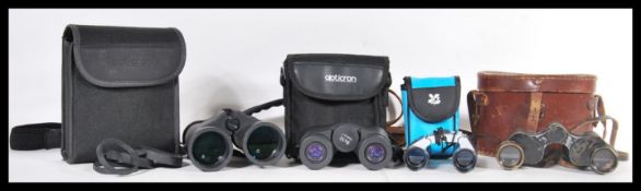A collection of binoculars to include a pair of vintage 20th Century binoculars in leather carry