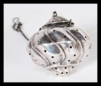 A 19th Century Chinese silver tea strainer of gadrooned form set in silver hook chain. Weighs 17.1