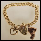 A 9ct gold hallmarked charm bracelet being adorned with boot, heart padlock and heart with
