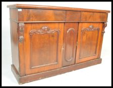 A 19th Century Victorian mahogany sideboard credenza having twin cupboard doors with carved scrolled