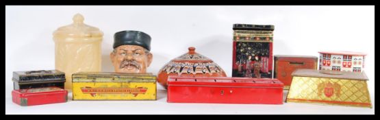 A collection of vintage retro tobacco jars and vintage advertising tins to include a character jar