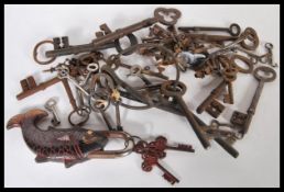 A collection of decorative antique keys of various sized and forms along with a pad lock in the form