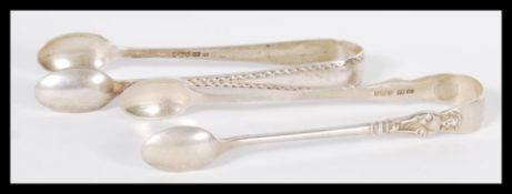 Two pairs of hallmarked silver sugar togs or nips comprising of an example with Ecclesiastical