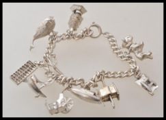 A 20th Century silver charm bracelet having ten charms including a whale, nodding dog, a boat,