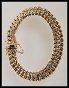 An UnoAERRE 9ct gold / 375 hallmarked gents bracelet strap with safety chain being stamped to the