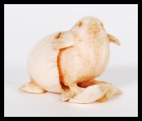 A 19th Century Japanese hand carved ivory netsuke figurine of a chick hatching from an egg. Signed
