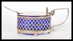 A silver hallmarked fret pierced blue glass lined mustard pot together with a silver hallmarked