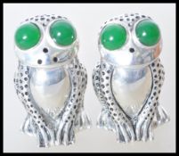 A pair of stamped 800 silver salt and pepper condiments in the form of frogs being set with large