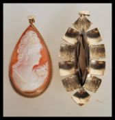 A 9ct gold / 375 hallmarked teardrop shaped cameo pendant being gadrooned to the edges with bale