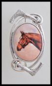 A stamped 925 silver equestrian riders brooch set with an oval enamelled panel depicting a horse