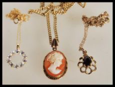 A group of three 9ct gold pendants comprising of a large faceted garnet set pendant on 9ct gold