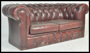A retro vintage ox blood red leather chesterfield sofa with barrel rolled arms and backrest being