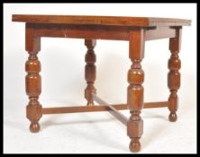 An early to mid 20th Century oak draw leaf dining table raised on turned baluster  upright