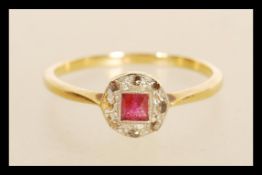 A stamped 18ct gold ring having a round platinum head set with a square cut ruby surrounded by