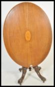 A 19th Century mahogany tilt top breakfast table raised on carved scrolled base. The oval top raised