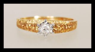 A hallmarked 18ct gold diamond single stone solitaire ring having bark effect band and shoulders