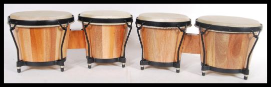 Two pairs of small Tom Tom drums, each with hide skins raised on wooden coopered bodies. Biggest