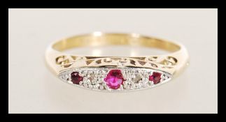 An 18ct gold stamped diamond and garnet stone ring having flush stone setting with scroll
