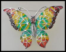 A stamped 925 plique a jour silver brooch in the form of a butterfly set with a oval cut red stone