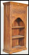 A 20th Century hardwood Eastern marriage / dowry cabinet bookcase having foliate carved