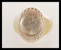 A hallmarked 9ct gold signet ring with engine turned decoration, weight 9.9g. Size T.
