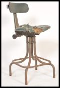 A vintage retro 20th Century industrial factory machinist stool chair raised on tubular legs and