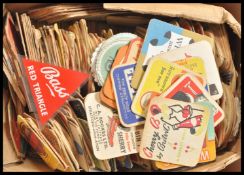 A large collection of vintage 20th Century advertising point of sale beer mats along with an acrylic