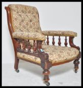 A Victorian 19th century mahogany armchair. Raised on turned legs terminating in castors. Above a