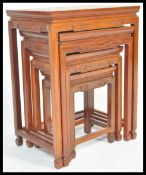 A 20th century nest of four Chinese hardwood graduating occasional tables, each with pierced