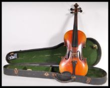 A vintage 20th Century violin musical instrument having a two piece maple back with spruce front.