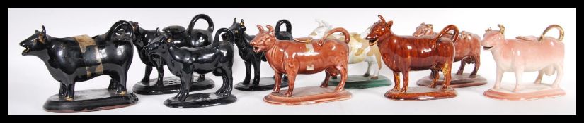 A collection of ceramic creamer jugs modelled as cows to include Staffordshire examples dating