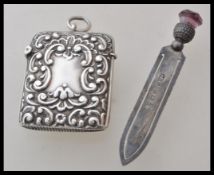 A silver hallmarked vesta case having raised rococo style scrolled decoration, a hinged lid to the