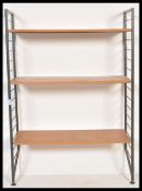 A vintage retro 20th Century Ladderax wall shelving unit having two ebonised ladder sides with three