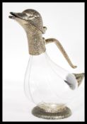 An early 20th Century silver plated and glass novelty claret jug in the form of a duck raised on a