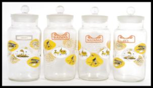A group of four vintage retro 20th Century glass kitchen storage jars complete with stoppers