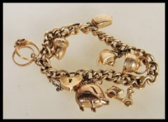 A hallmarked 9ct gold charm bracelet having a curb link bracelet chain with heart padlock clasp.