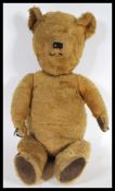 A vintage mid 20th Century childs teddy bear constructed from mohair with leather patches to the