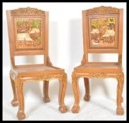 A pair of 20th century carved hardwood hall chairs having carved in relief panel back rests with